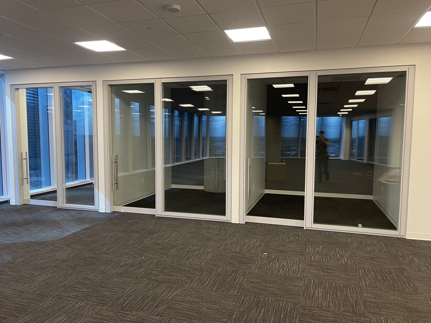 Multi-bay glass office partitions in a corporate lobby